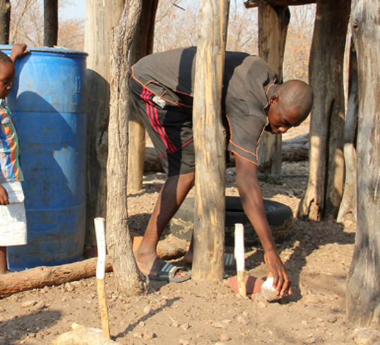 A father and son stand near sticks and rocks used to mark safe land 