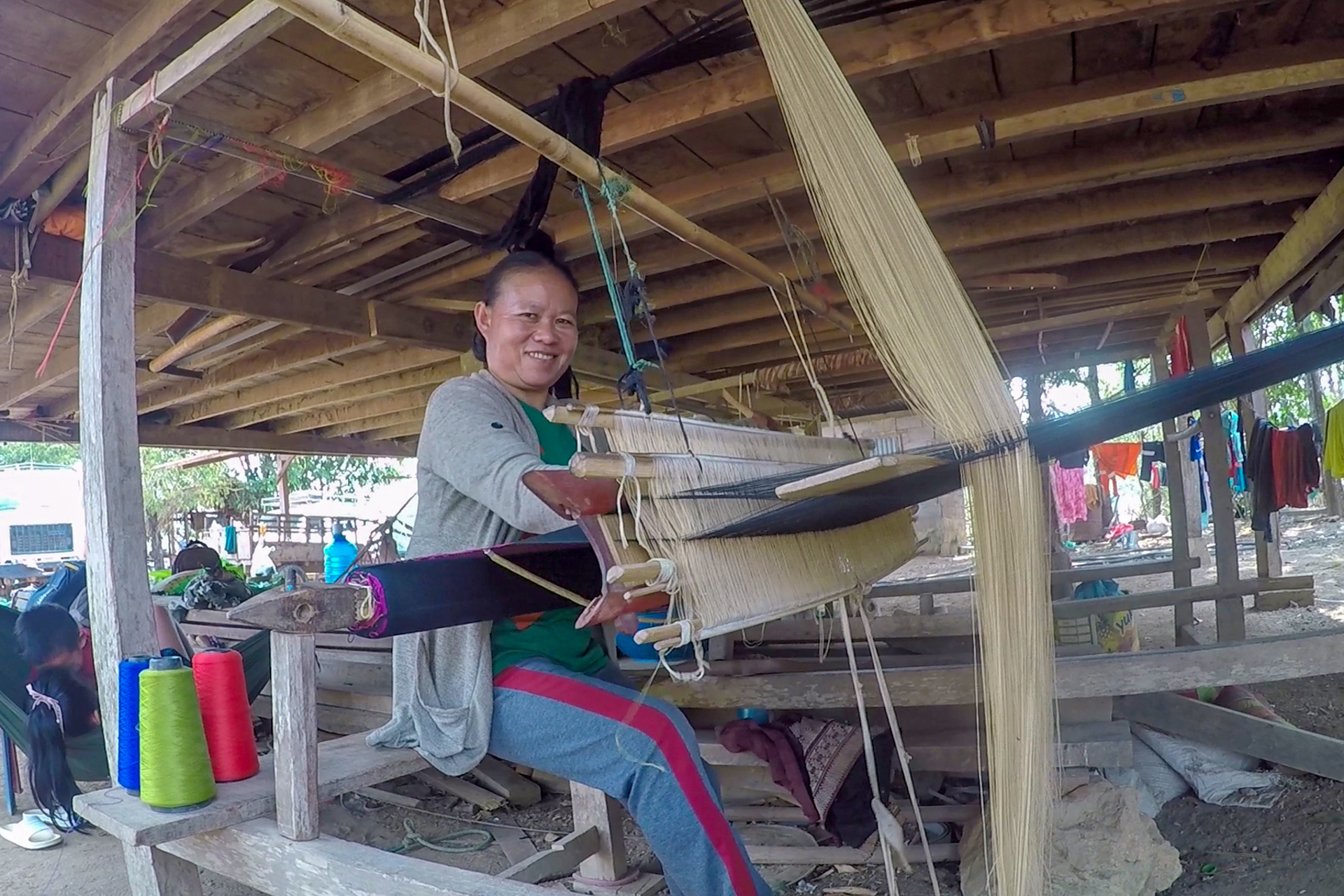 A villager weaves on a loom in Laos