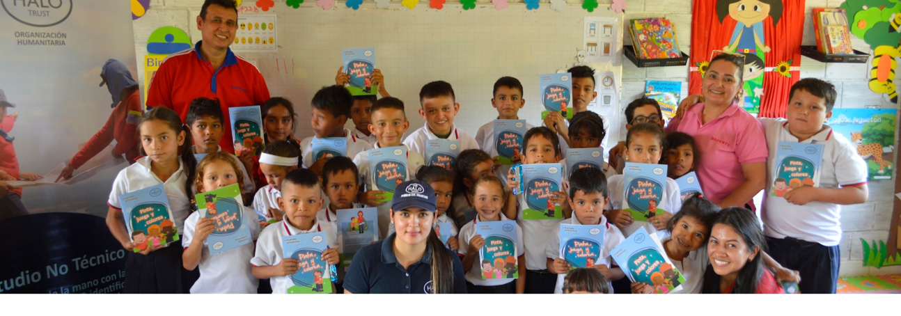 HALO risk educators pose with school children in a class after a explosive ordnance risk education session