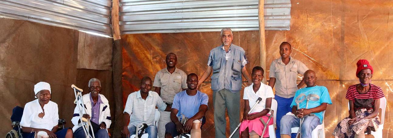 Landmine survivors pose a a group, wearing their prosthetic legs from Cassim's clinic