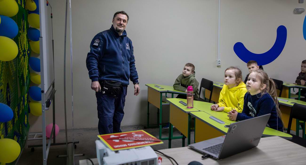 Спеціаліст х мінної просвіти навчає дітей безпечній поведінці при зустрічі з мінами