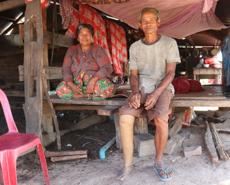 Cambodian man and woman sit on a bench