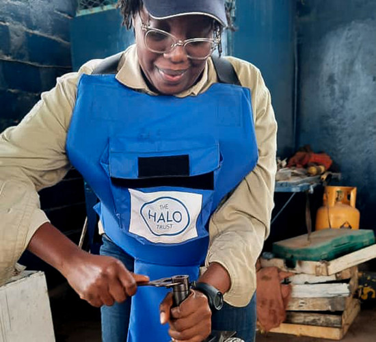 Jessica uses a spanner during training while wearing HALO protective gear