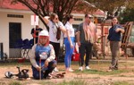 A deminer works on the ground as US Congressional staffers listen to a HALO staff member talking