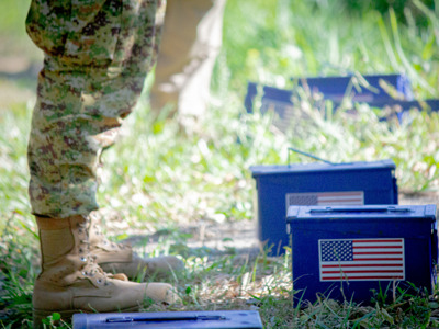 A close shot of military personnel standing in front of small blue boxes with the US flag