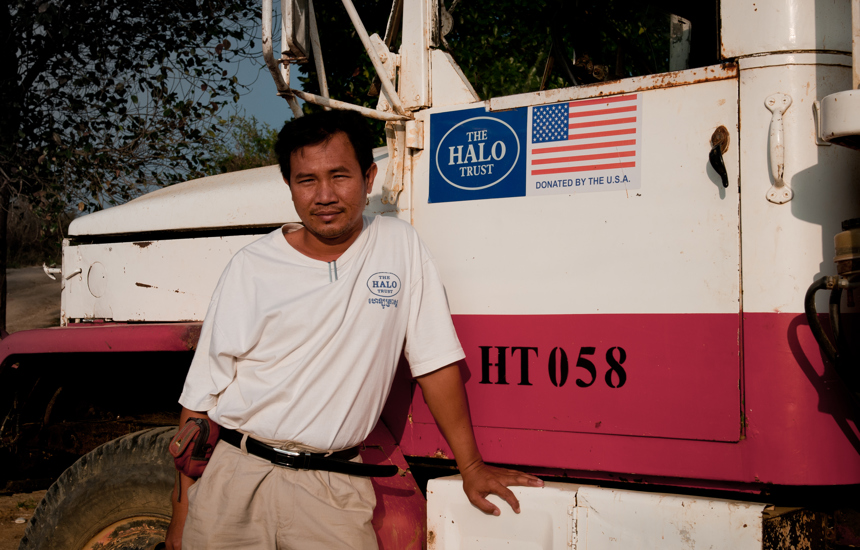 A HALO staff member poses in front of a US badged HALO truck