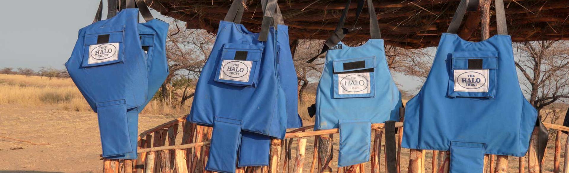 PPE vests hanging on a wooden fence