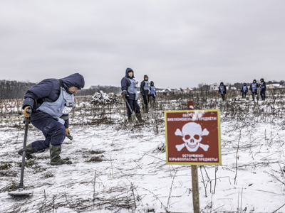 Deminers standing on a snowy minefield