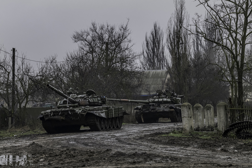 Military tanks drive down a muddy road in Ukraine