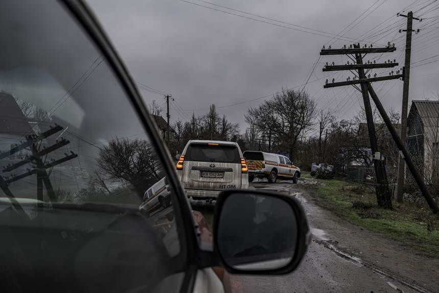 Wing mirror shot of a fleet of cars driving down a wet road in Ukraine