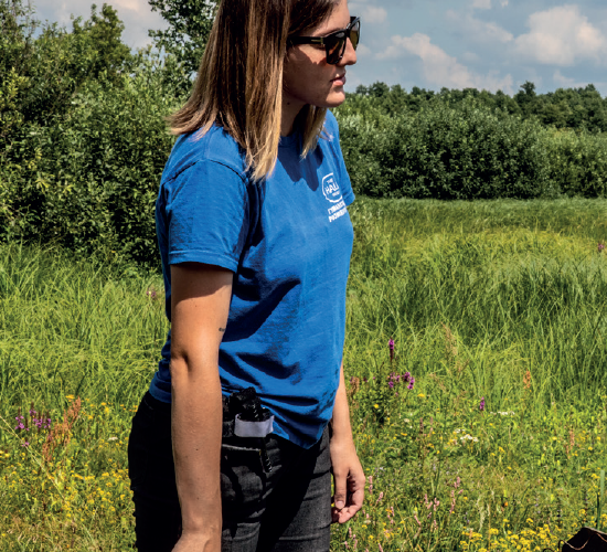 Dariia, a HALO staff member stands in a field outside