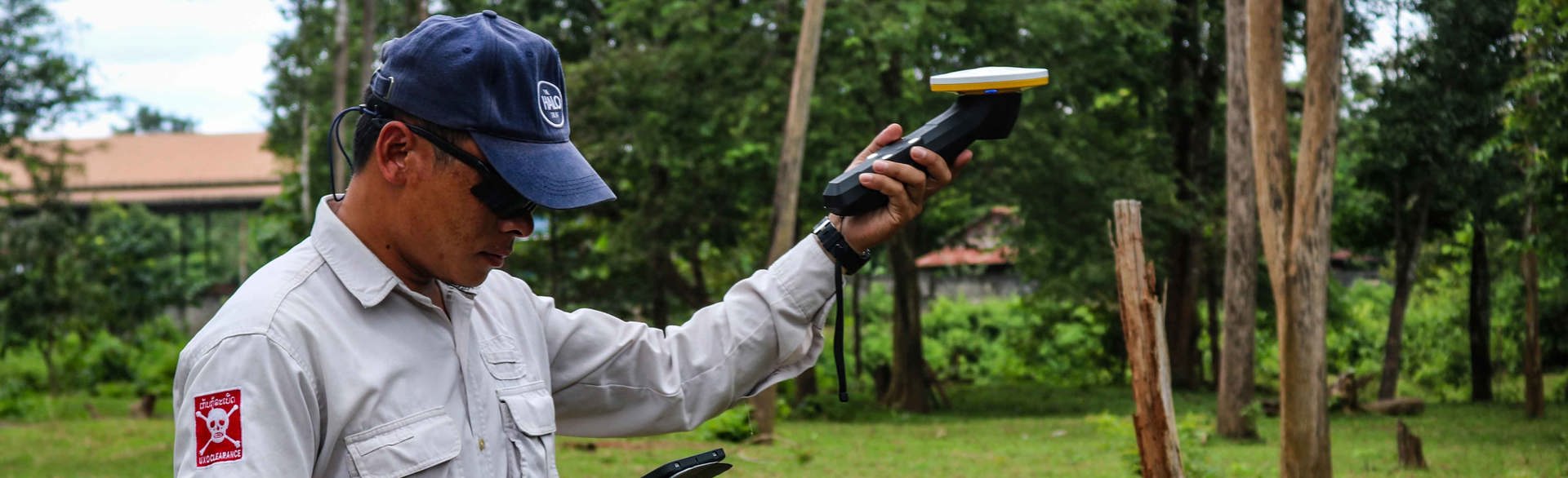 HALO Trust technician using a digital GPS unit to mark the edge of a crater caused by a bomb