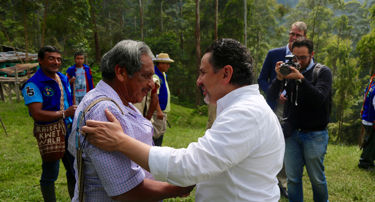Two men from the Kwet Wala Indigenous Reserve shake hands outside