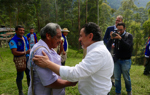 Two men from the Kwet Wala Indigenous Reserve shake hands outside