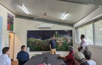 A HALO staff member leads a meeting with colleagues and representative Ami Bera sitting around a table