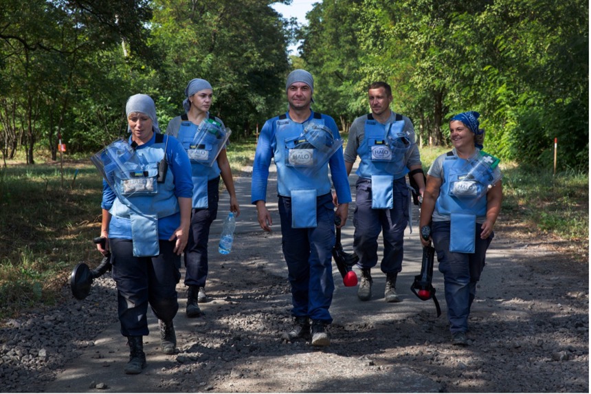 Demining Team in Zolotynka Village, walk down a path with their demining gear