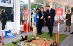 Prince Harry talks with a HALO Trust staff member wearing a protective vest near a display minefield at an event