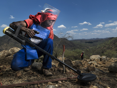 HALO staff member wearing PPE and scanning for explosives