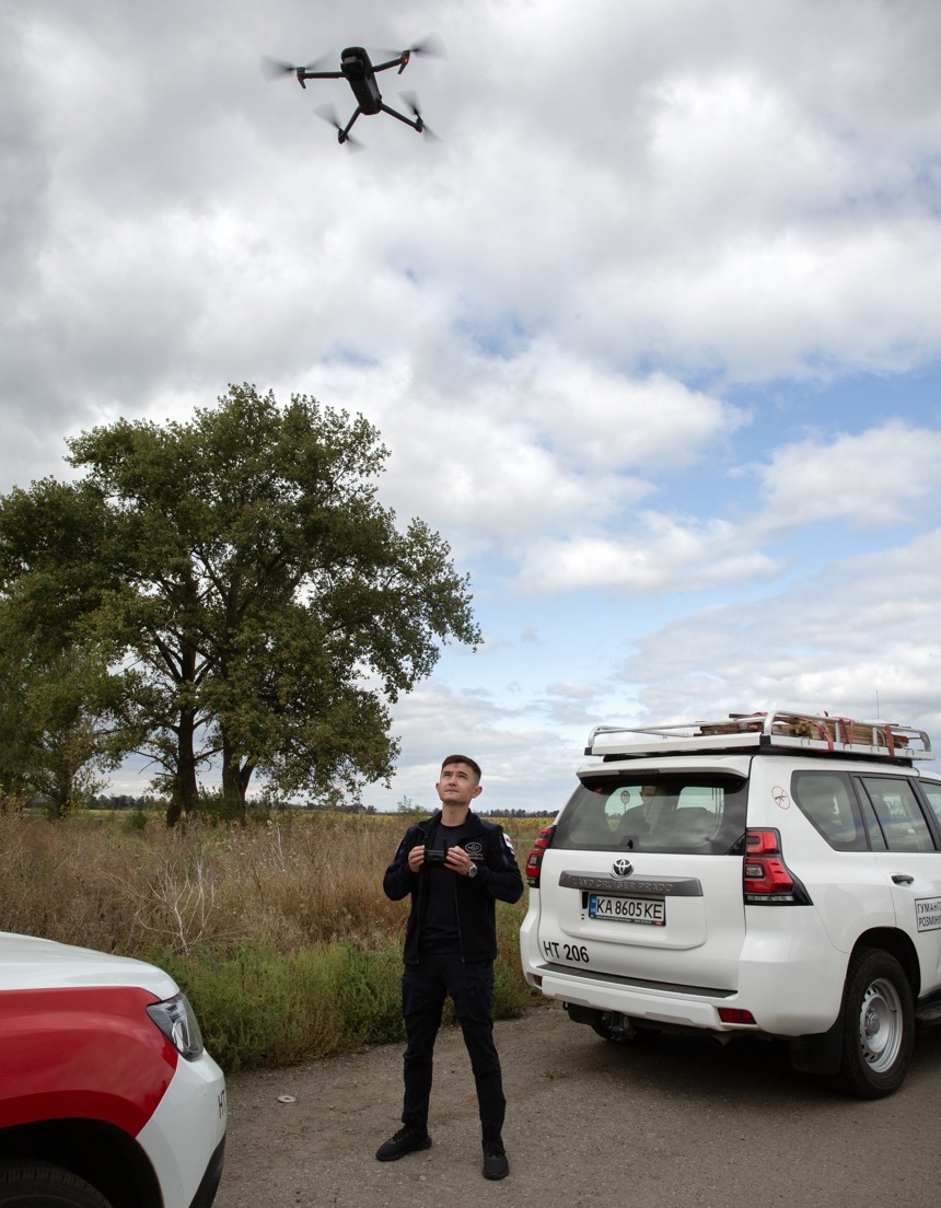 Ihor Lee, flies a drone between two vehicles in Havrilivka Village 