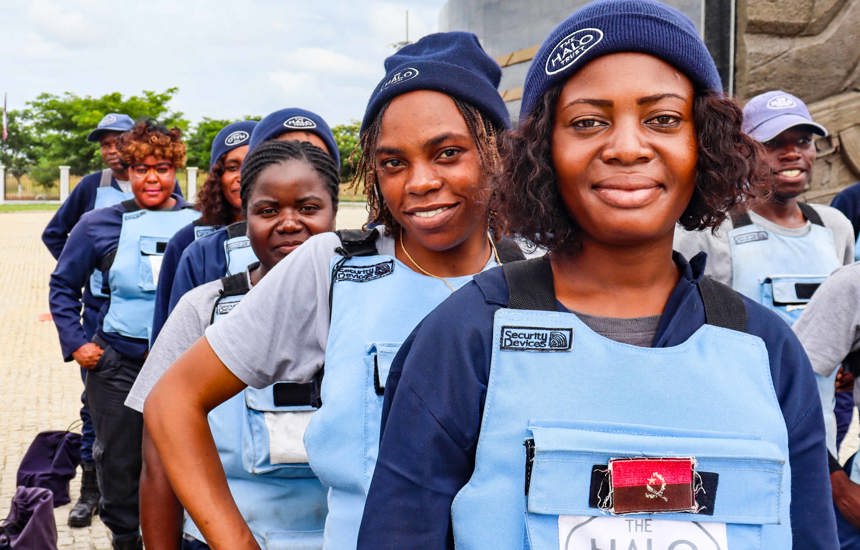 A group of female deminers stand in a line wearing HALO PPE and hats 