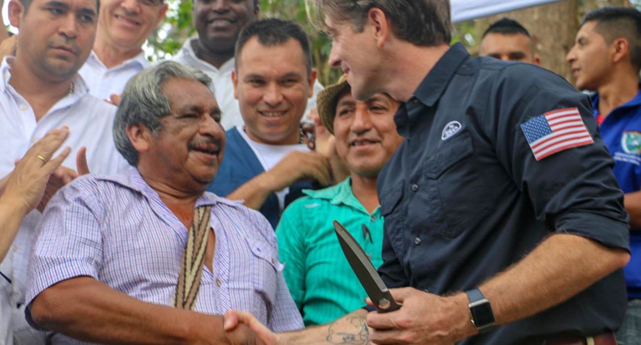 A US staff member shakes hands with a local with a small crowd behind them