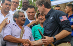 A US staff member shakes hands with a local with a small crowd behind them