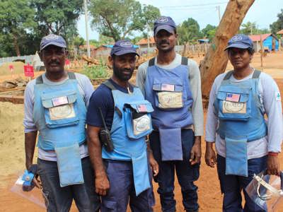 The mechanical demining team pose together outside