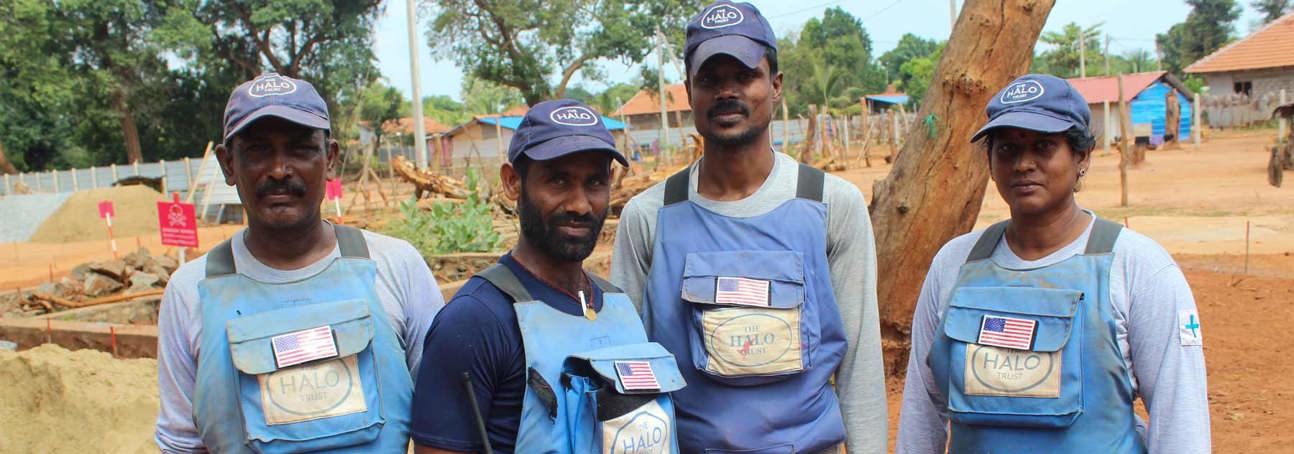 The mechanical demining team pose together outside