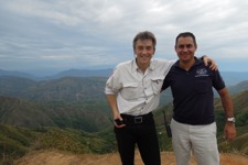 Tim Porter poses with a HALO staff member with a shot of the Colombian valleys behind them