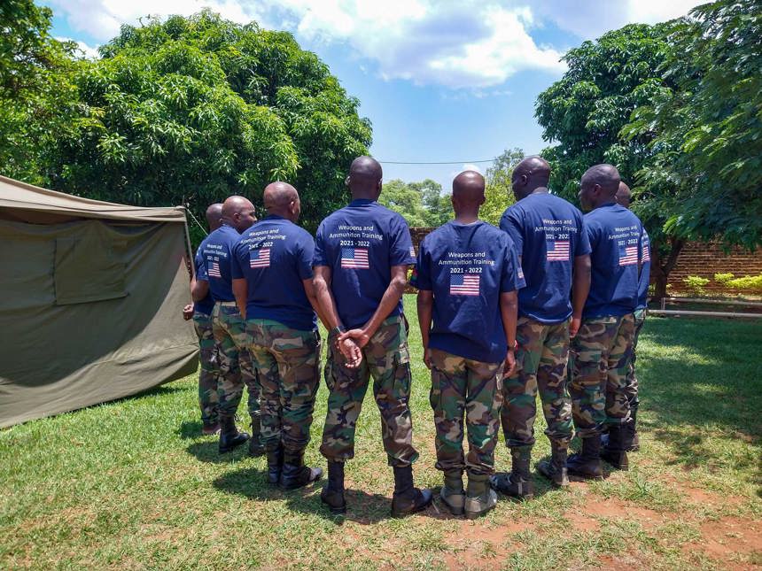 Weapons and ammunitions training squad stand outside huddled together 