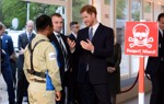 Prince Harry talks with a HALO Trust staff member wearing a protective vest near a display minefield at an event