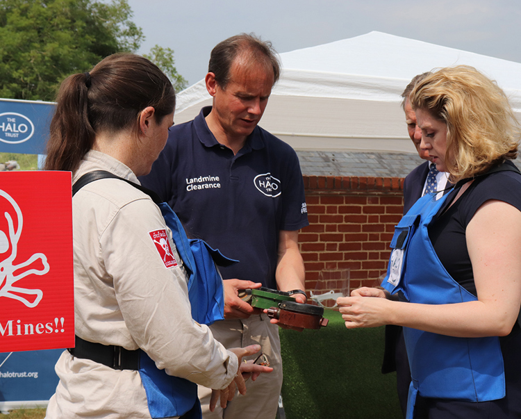 James Cowan, shows Penny Mordaunt various types of mine during a visit to the HALO Office
