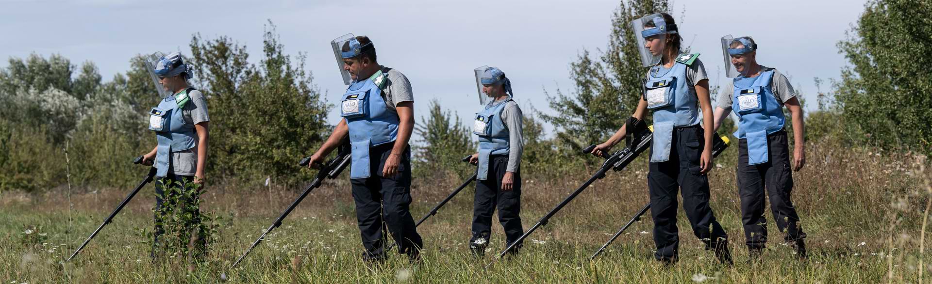 Група демінерів проводить пошук вибухонебезпечних предметів на поверхні грунту за допомогою детекторів