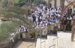 Pilgrims gathered at the Baptism Site of Christ, some wading into the Jordan River, participating in the Epiphany celebration