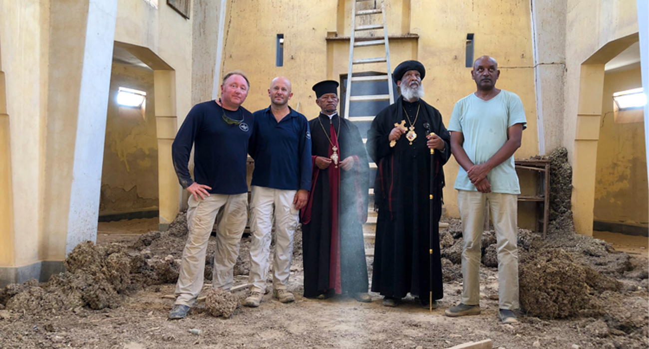 HALO staff stand with religious leaders inside the cleared church