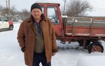 Іван Васильович біля трактора серйозно дивиться в камеру