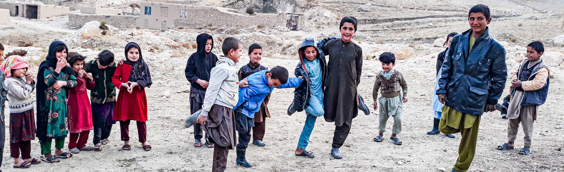 Children stand together smiling in a  district of Samangan province