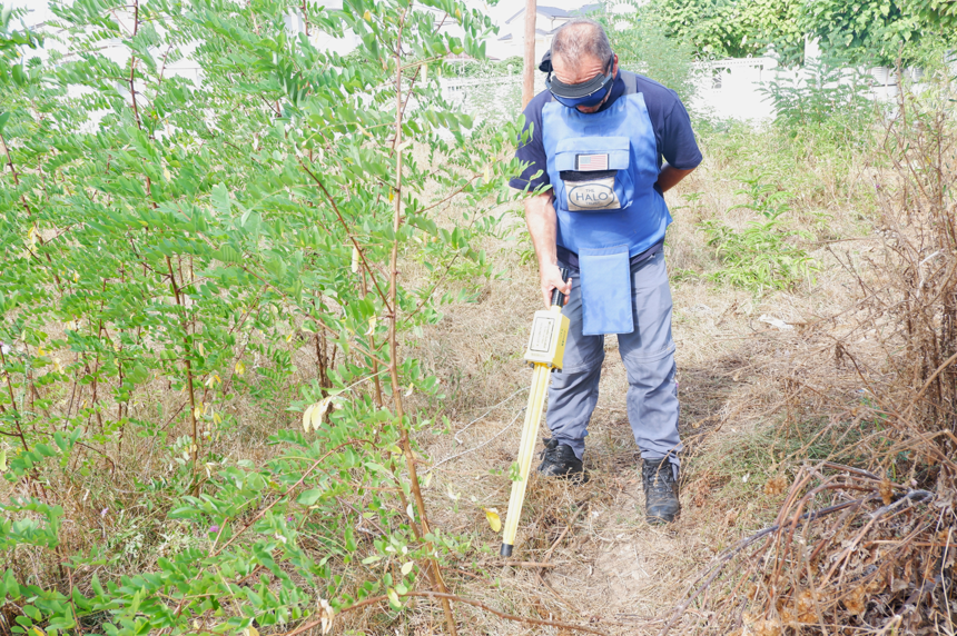 Shkëlzen Zeqa, HALO Team Supervisor, uses a Schonstedt Magnetic Locator in a forest