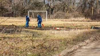 Deminers use metal detectors to scan a minefield in kharkiv oblast