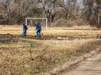 Deminers use metal detectors to scan a minefield in kharkiv oblast