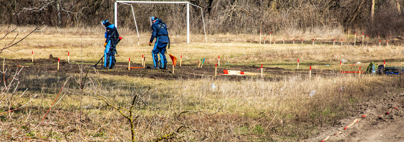 Deminers use metal detectors to scan a minefield in kharkiv oblast