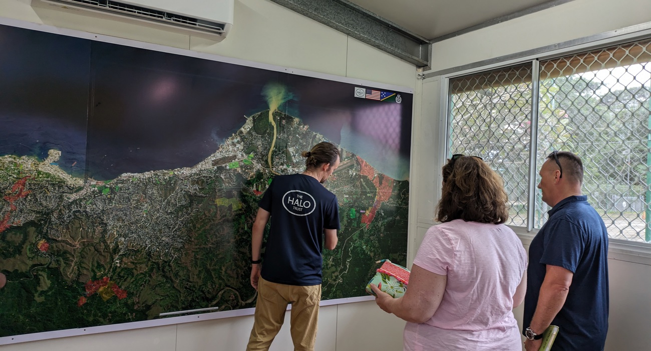 Halo staff member points to a map of the Solomon Island coast