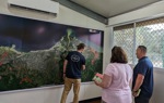 Halo staff member points to a map of the Solomon Island coast