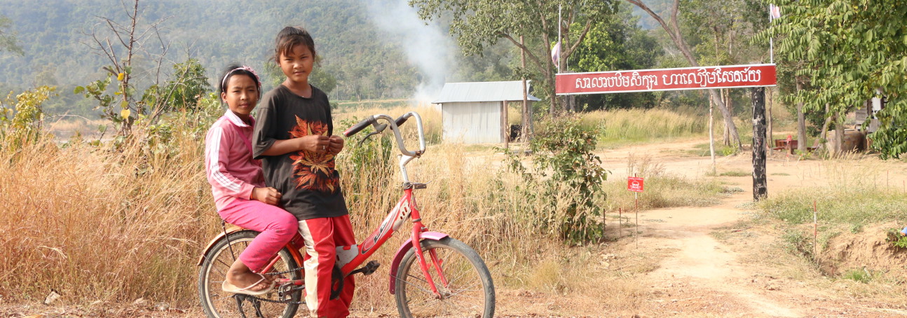 Two children on a bicycle in rural Cambodia