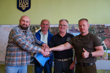 A group of men pose for a handshake