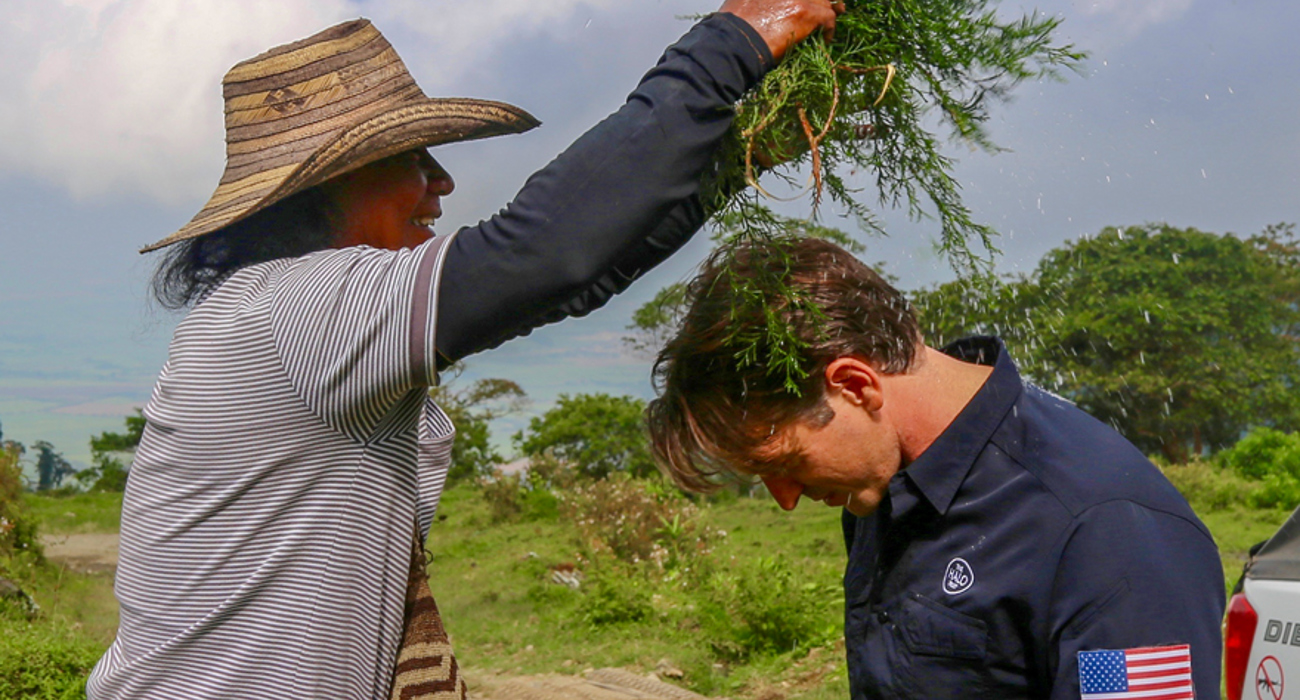 A woman drips water from wet plants above a US staff members head