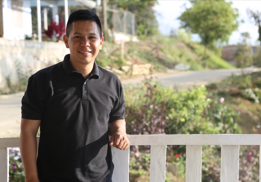 Deiner, Grandson of Alba, leans on a white fence and smiles