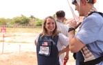 US Congressional staffers wear PPE in front of a mine marked field