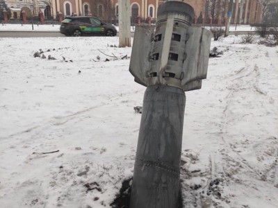 An unexploded ordinance sits half buried into the snowy ground