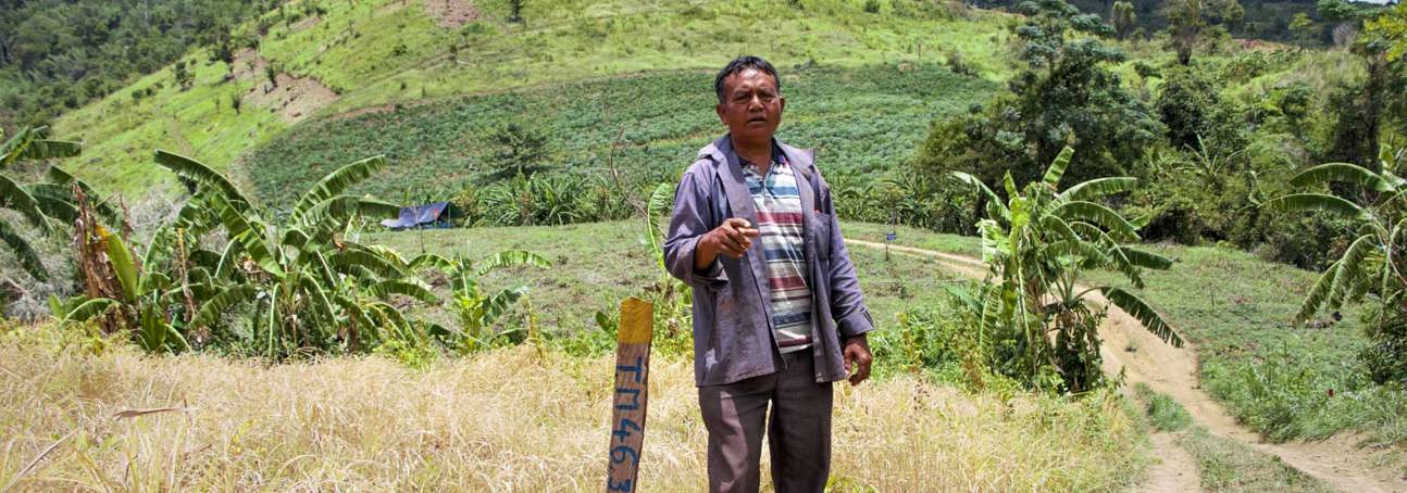 Pork Chei stands next to a anti tank mine marker in Cambodia